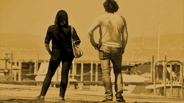 a couple seen from the back looking out at a house